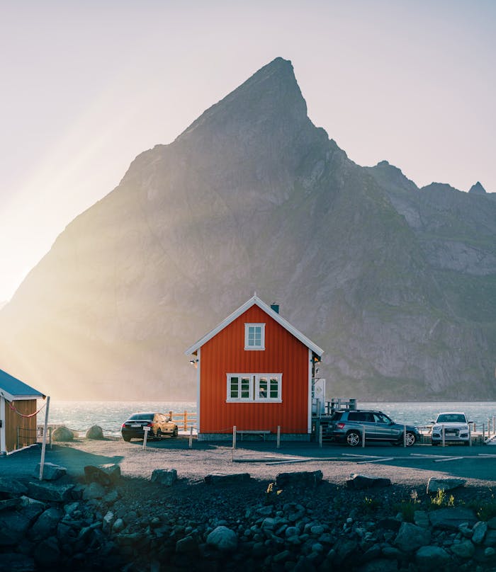 Picturesque scene of a small red house at sunset in scenic Reine, Norway.
