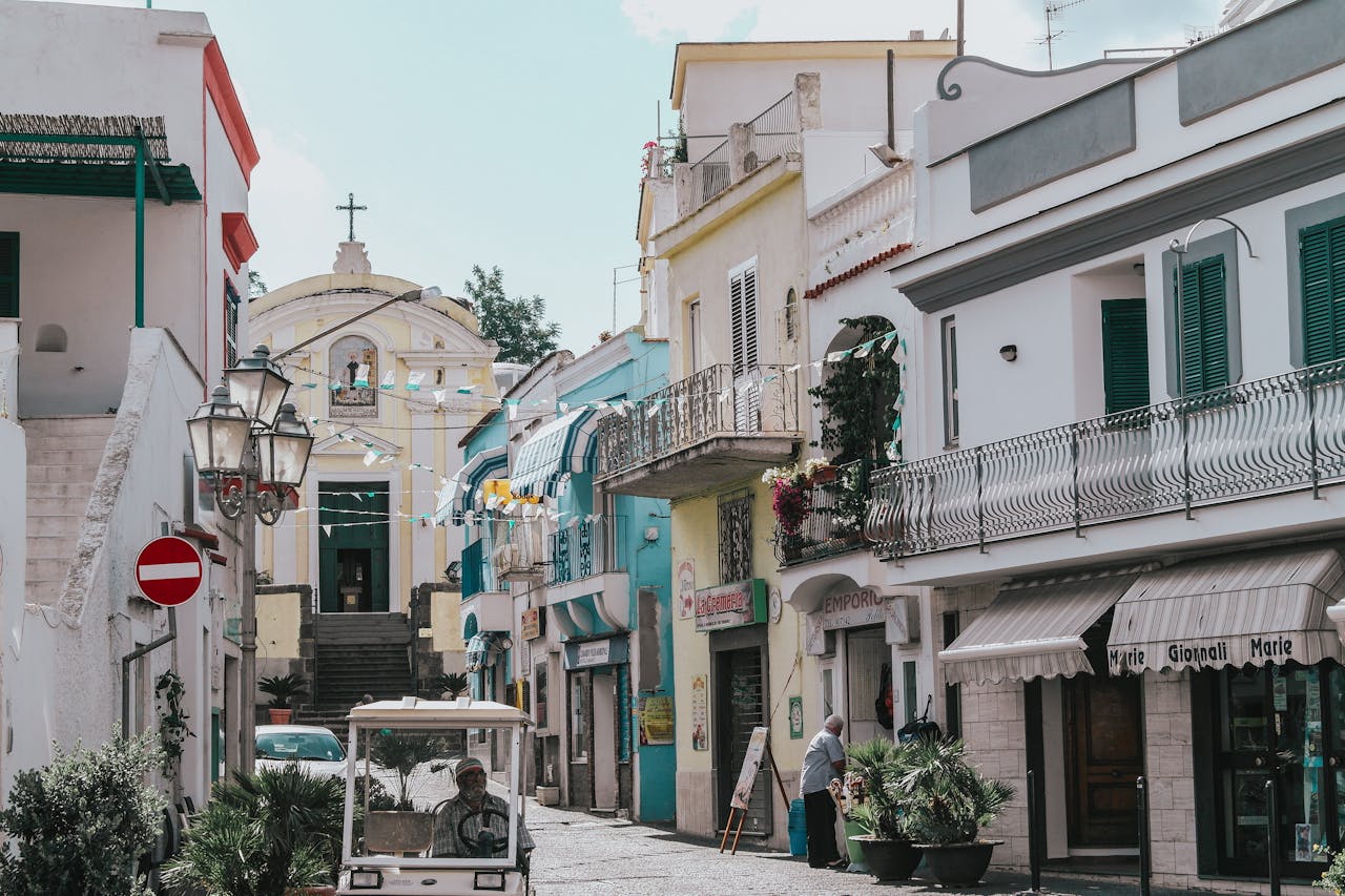 Quaint street view in Ischia, Italy showcasing colorful facades and local life.